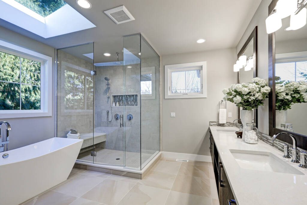 Freestanding soaking tub beneath skylight in spa-inspired bathroom renovation